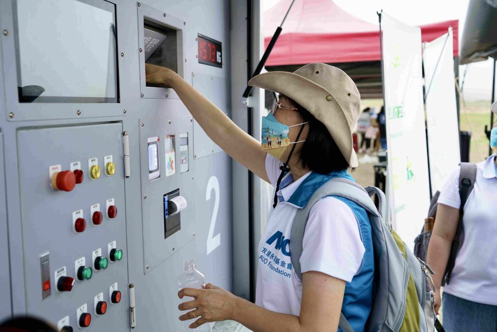 志工們將拾起的寶特瓶投入「好歸塑專車」，讓廢棄塑料空瓶可以直接粉碎、縮小體積，未來將可再製成購物袋、寶特衣、悠遊卡等生活用品